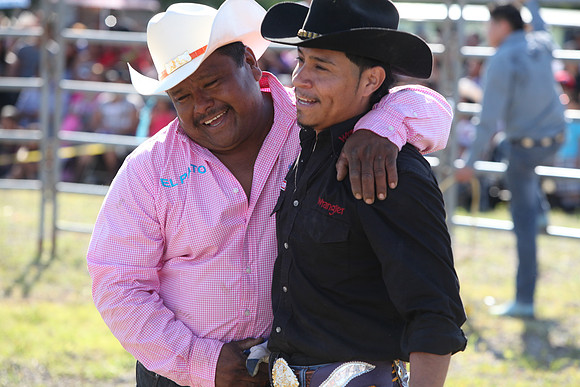 A bull rider is greeted after a successful ride.